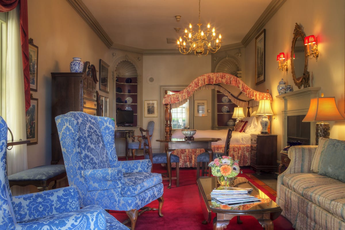 A traditional room with a chandelier, patterned furniture, and a fireplace.