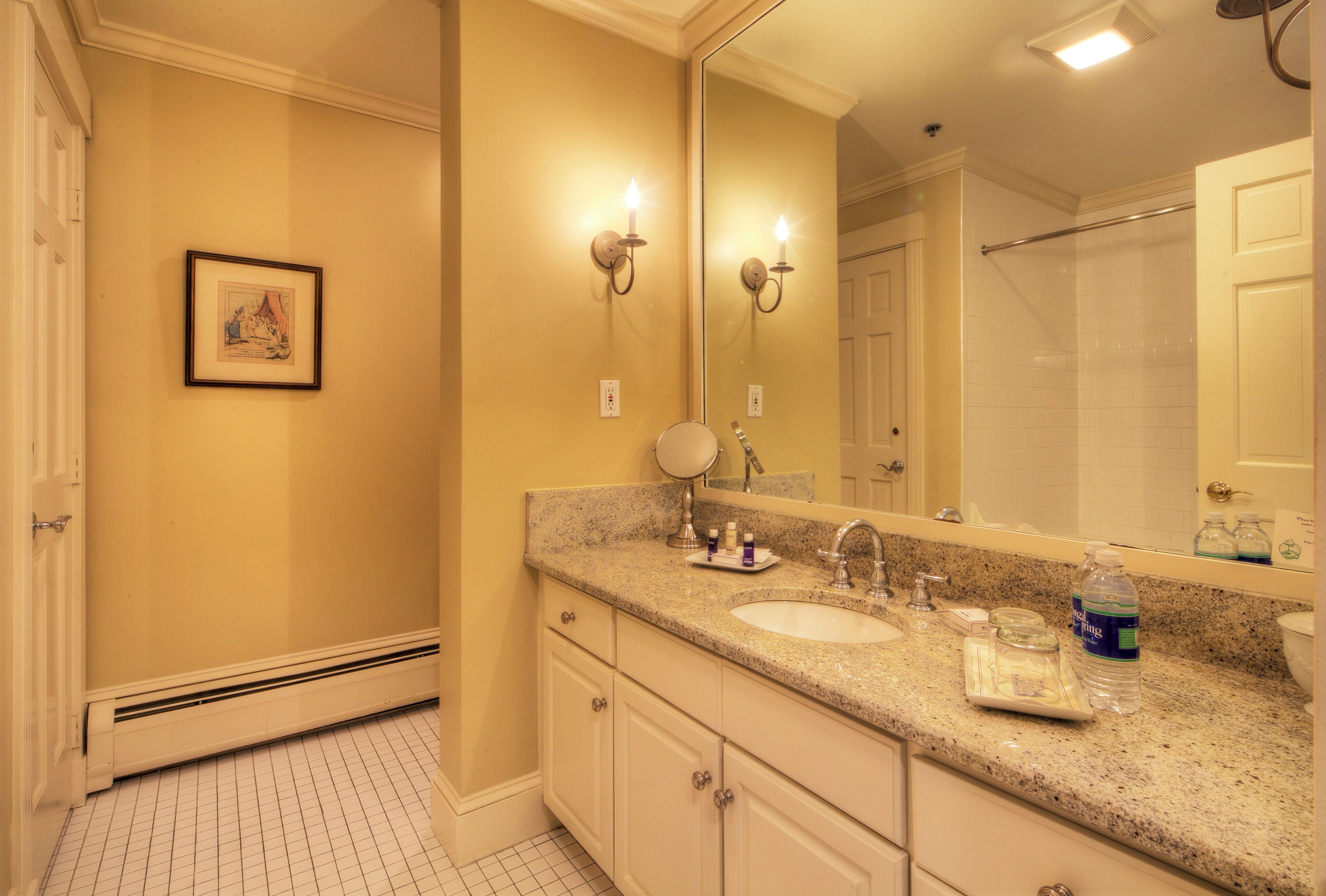 A bathroom with two sinks, a large mirror, and a framed picture on the wall.