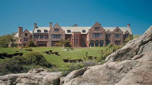 A large, multi-story stone building with a symmetrical facade, large windows, and a well-maintained lawn in front. - Francis Malbone House Inn (Newport)
