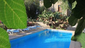 Een seizoensgebonden buitenzwembad en parasols bij het zwembad