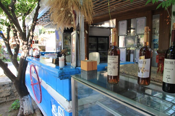 Uma área de bar com garrafas de vinho e um balcão azul.