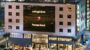 A modern hotel with a large illuminated sign reading "Normas Hotel" and Arabic text. - Normas Hotel (Al Khobar)
