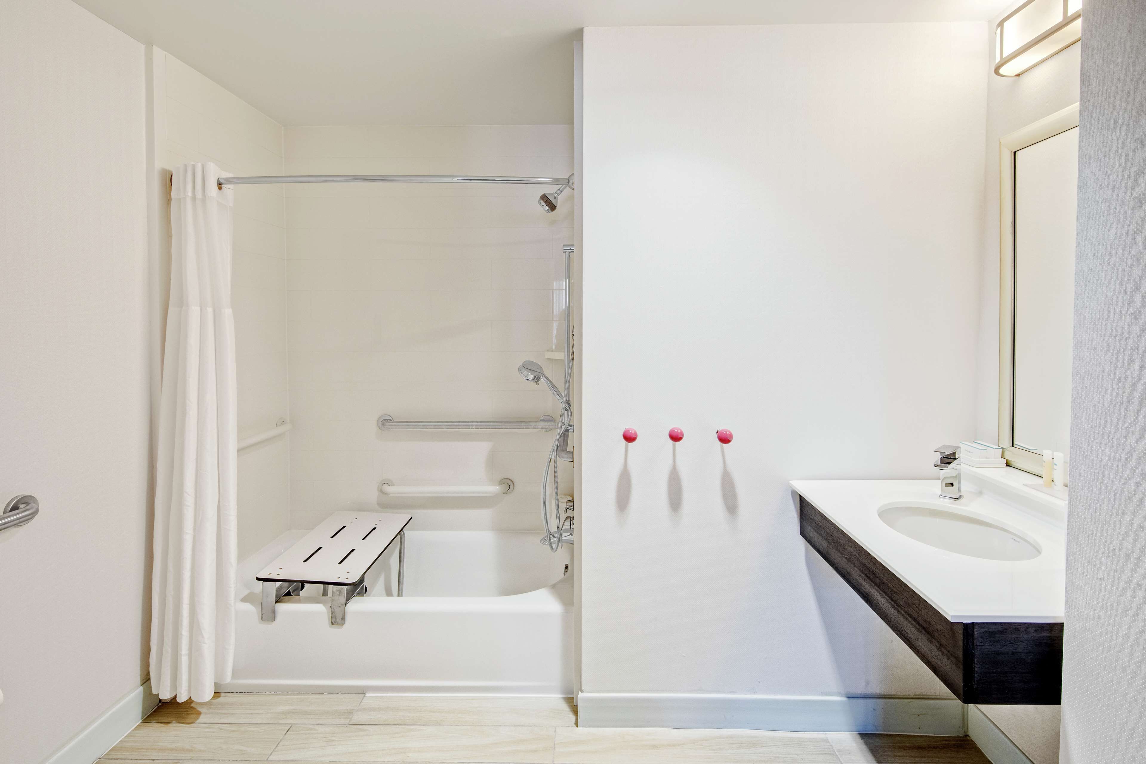 Een moderne badkamer met een inloopdouche, een witte badkuip en een wastafel met spiegel.