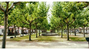 A park with rows of trees and small buildings with red roofs. - Camping Bungalow Parque Isábena (Isabena)