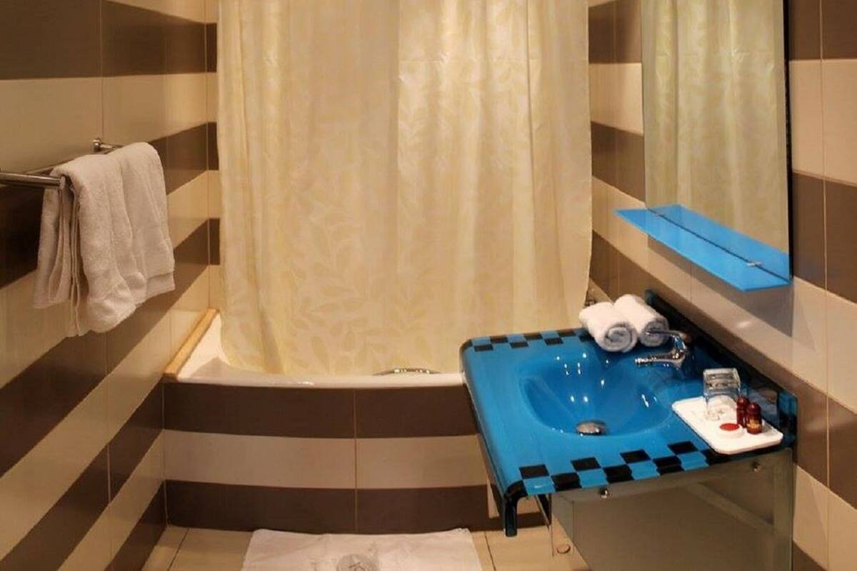 A bathroom with a bathtub, a sink, and a mirror.