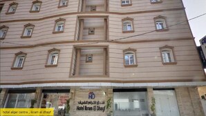 Un edificio de varios pisos con un letrero que dice 'Hotel Alger Centre, Ikram El Dhayf'.