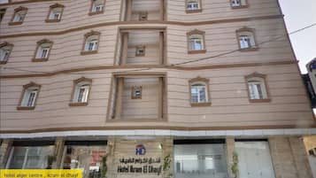 Un edificio de varios pisos con un letrero que dice 'Hotel Alger Centre, Ikram El Dhayf'.