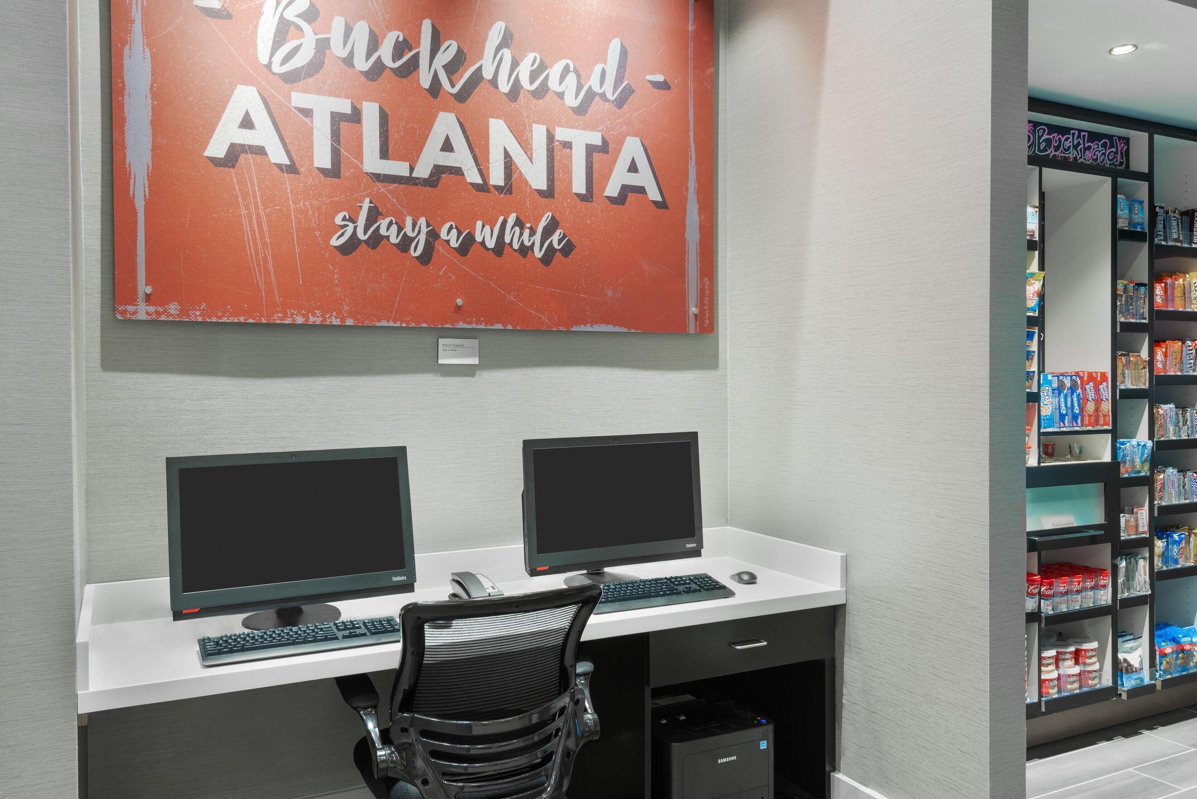 A workspace with two monitors, a keyboard, and a chair.