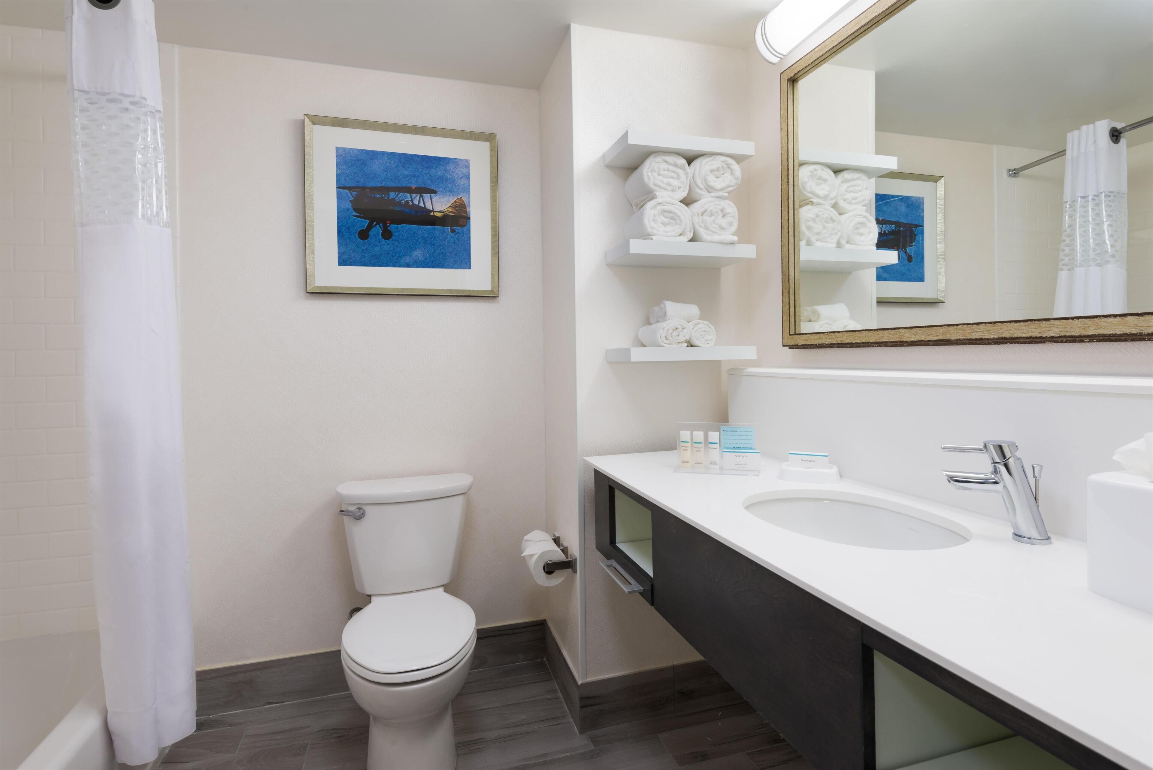 A modern bathroom with a toilet, a sink, and a shower curtain.