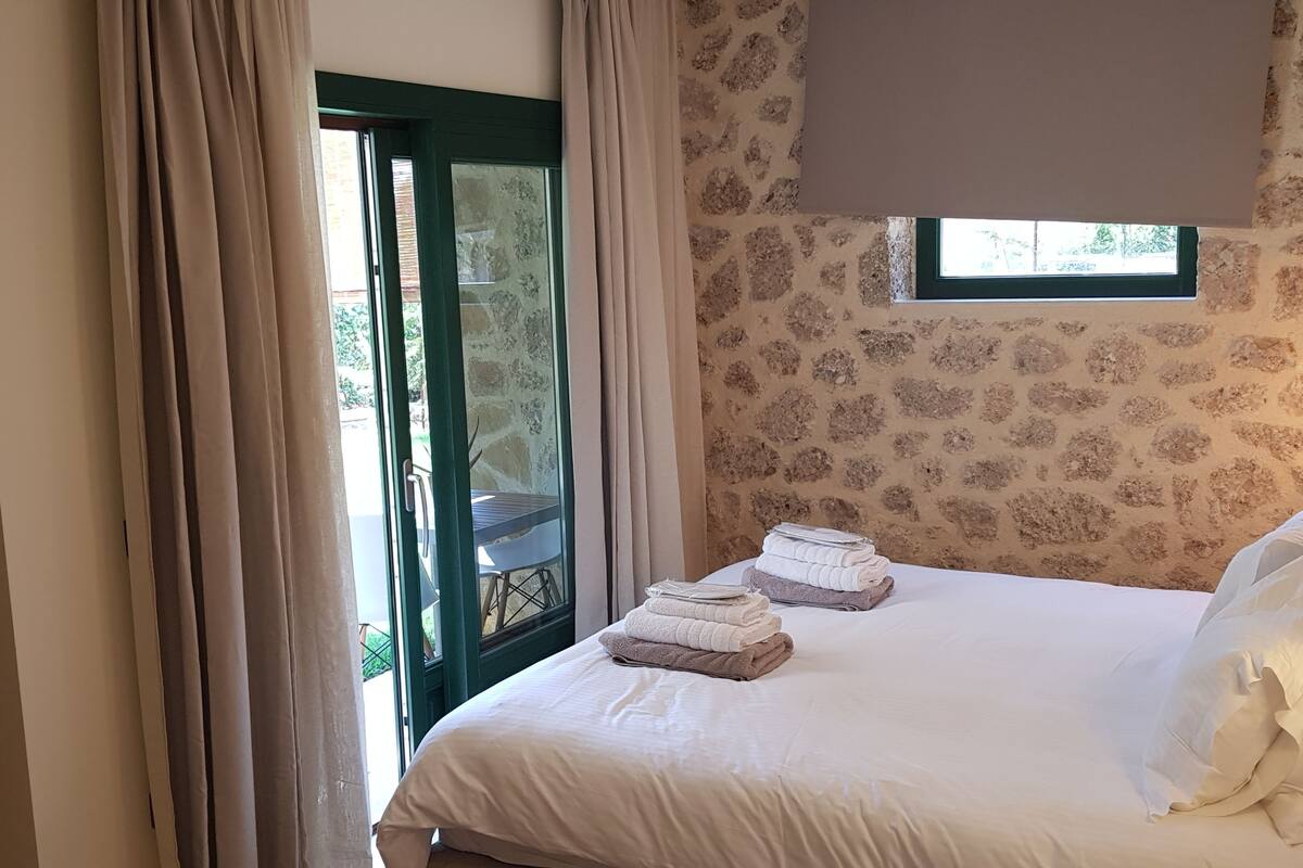 A bedroom with a bed, a window, and a view of the outside.