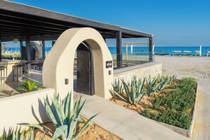 A beachside restaurant with outdoor seating, a view of the ocean, and a sign indicating 'Beach House.' - Atermono Boutique Resort & Spa  (Rethymno)
