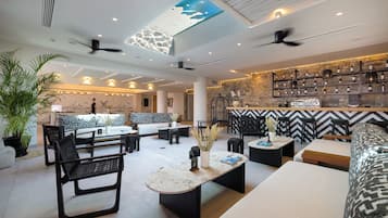 A modern lounge area with seating, a bar, and a ceiling with a skylight.