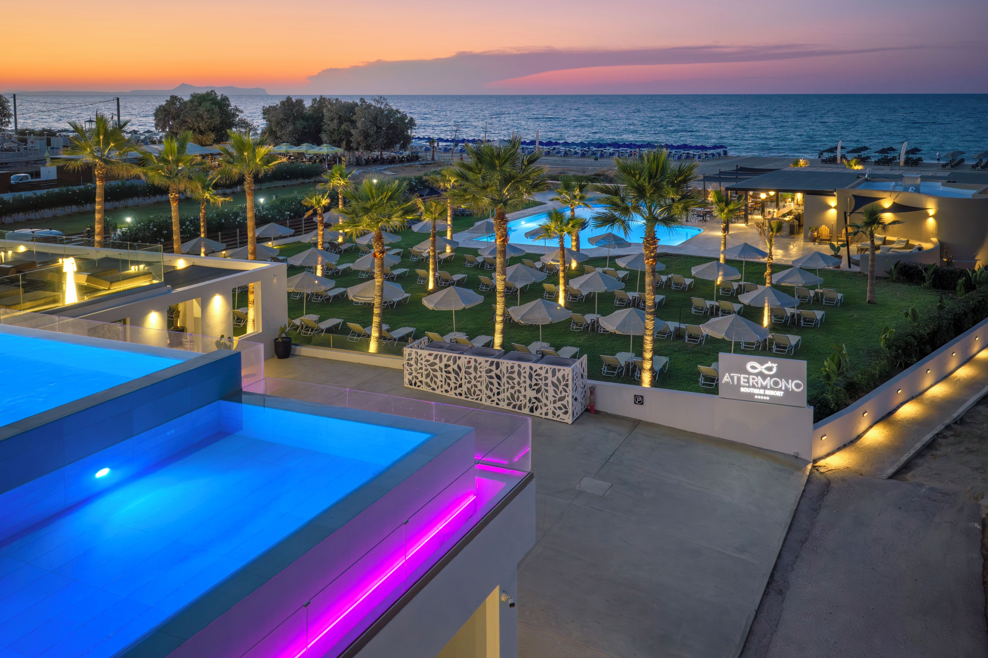A resort with a pool, lounge chairs, and umbrellas.