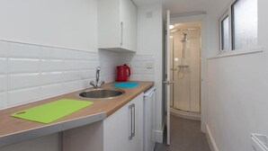 A compact kitchen with white cabinets, a sink, and a countertop. - Townhouse @166 Ruskin Rd (Crewe)