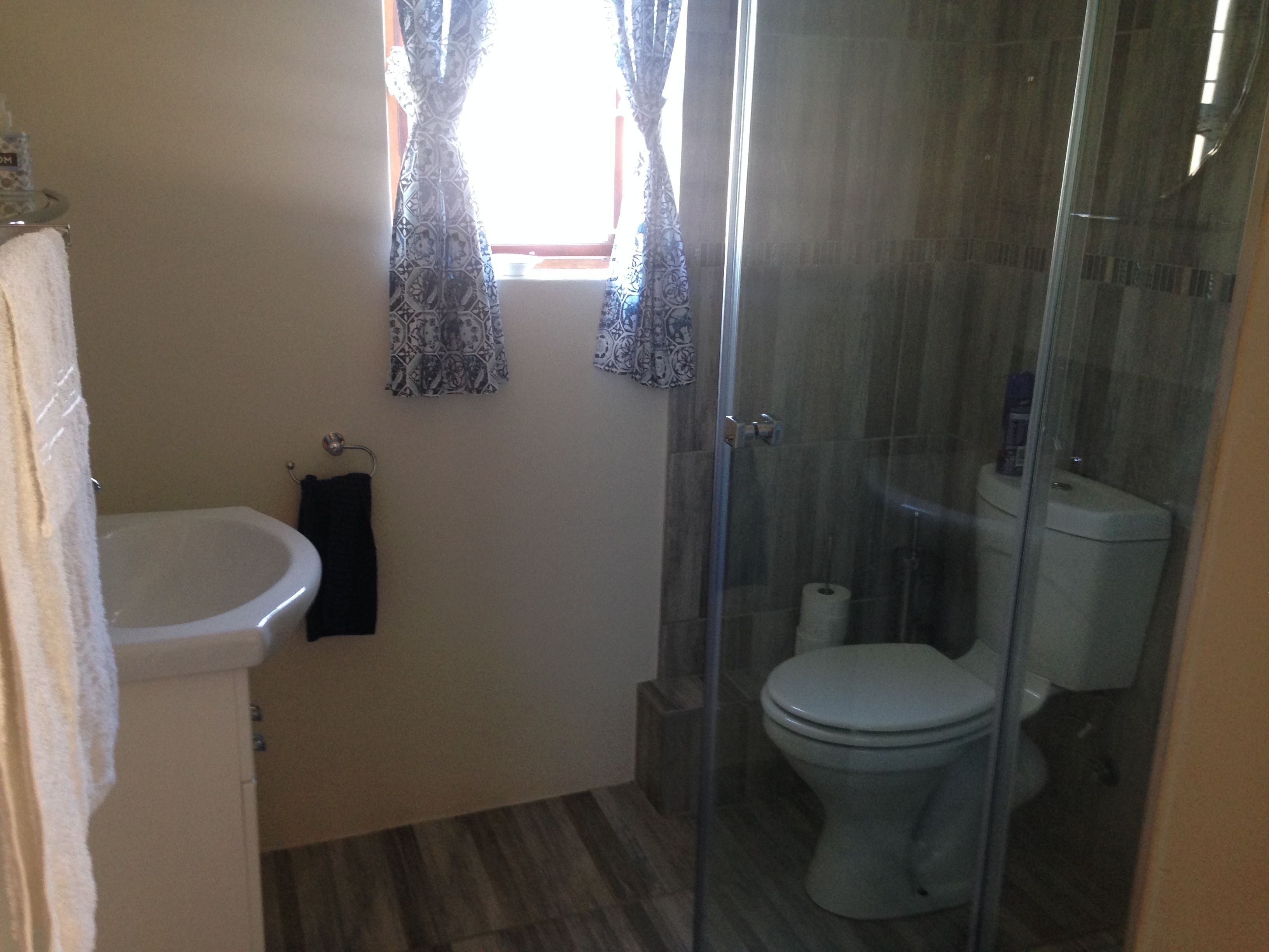 A bathroom with a toilet, a bidet, and a glass shower enclosure.