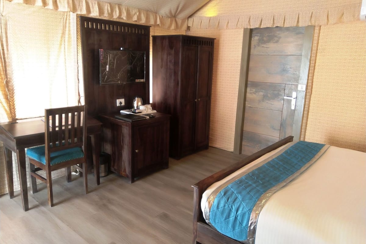 Una habitación de hotel con cama, escritorio, silla y armario.