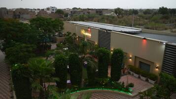 A hotel with a rooftop garden, a signboard, and a view of the surrounding area.