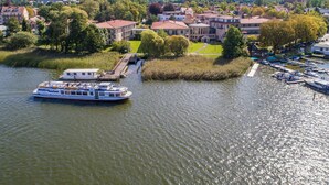 Ein Fluss mit einem Boot an einem Anleger, umgeben von Wohnhäusern und Grünflächen.