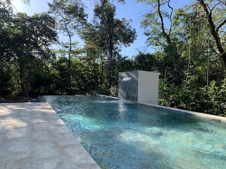 Una piscina al aire libre, sillones reclinables de piscina
