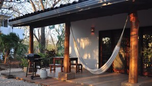 A covered outdoor area with a hammock, a grill, and a table. - Pazifico Villas (Tamarindo)