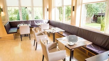 Un comedor moderno con disposición de asientos y ventanas amplias.