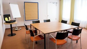A conference room with a large table, chairs, a whiteboard, and a projector. - Heidehotel Bad Bevensen (Bad Bevensen)