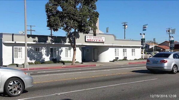 A motel with a sign reading "El Grande Motel" on a clear day.
