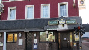 A red brick building with multiple windows and a sign for a restaurant. - Eifel Quartier Em Garstüffje (Mechernich)