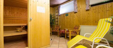 Un sauna de madera con puerta de madera, un banco y una mesa con sillas.