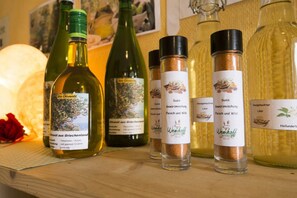 Bottles of olive oil and seasoning on a wooden shelf. - Kleines Hotel Wemhoff (Winterberg)