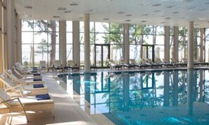A large indoor swimming pool with lounge chairs and sunbeds along the sides. - Zeleny Dom (Kobuleti)