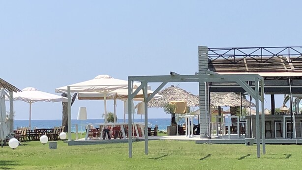 A beachside resort with outdoor seating areas, umbrellas, and a view of the sea. - AM Beach House near Sea (Nea Propontida)