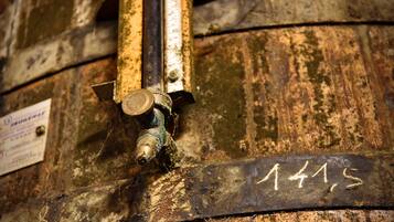 Primer plano de un barril de madera con una tubería metálica y una placa de metal que dice '1415'.