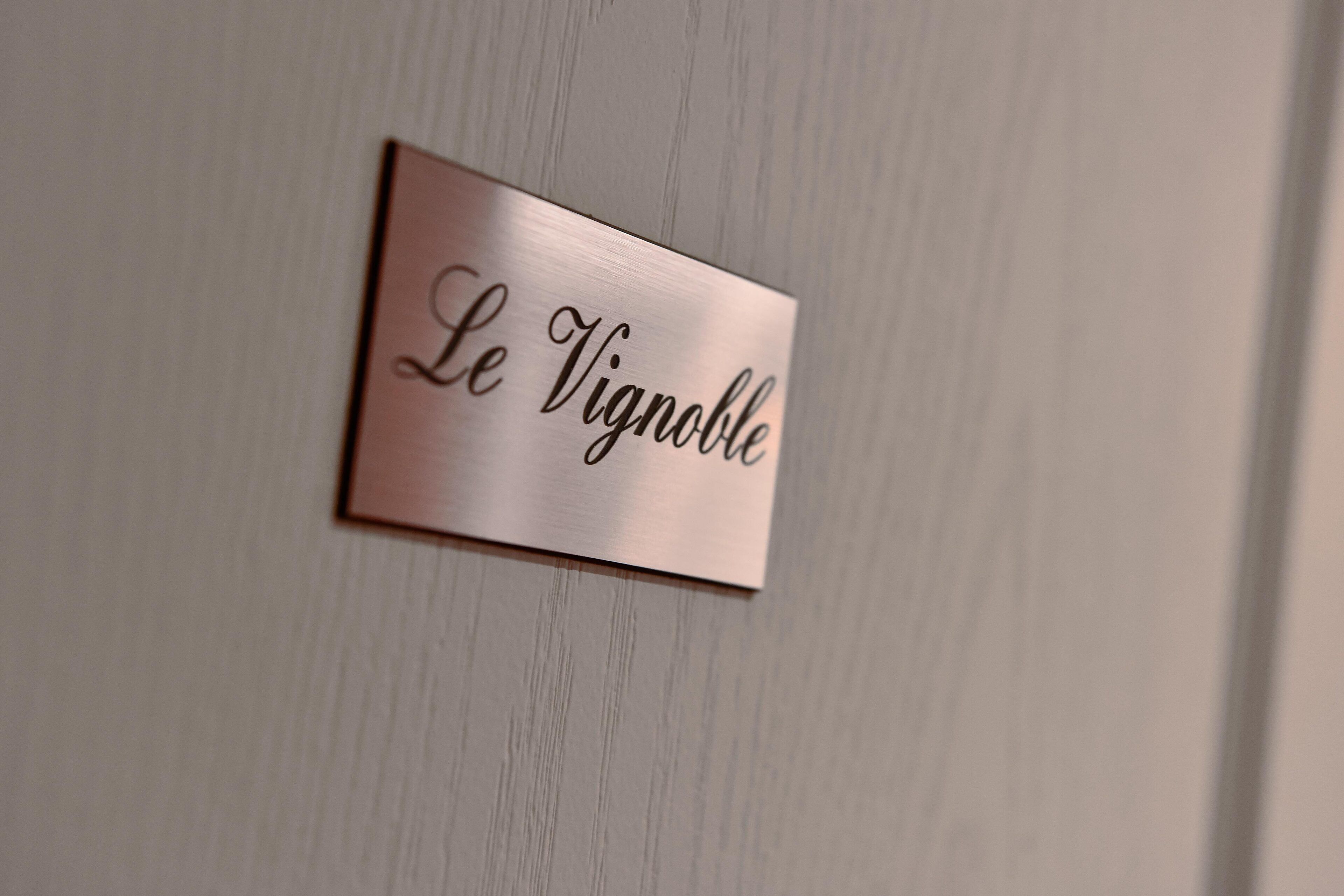 Een metalen plaquette met de tekst 'Le Vignoble'.