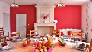 A breakfast setup with pastries, coffee, and juice on a wooden table. - Domaine d'Arcalis (Archiac)