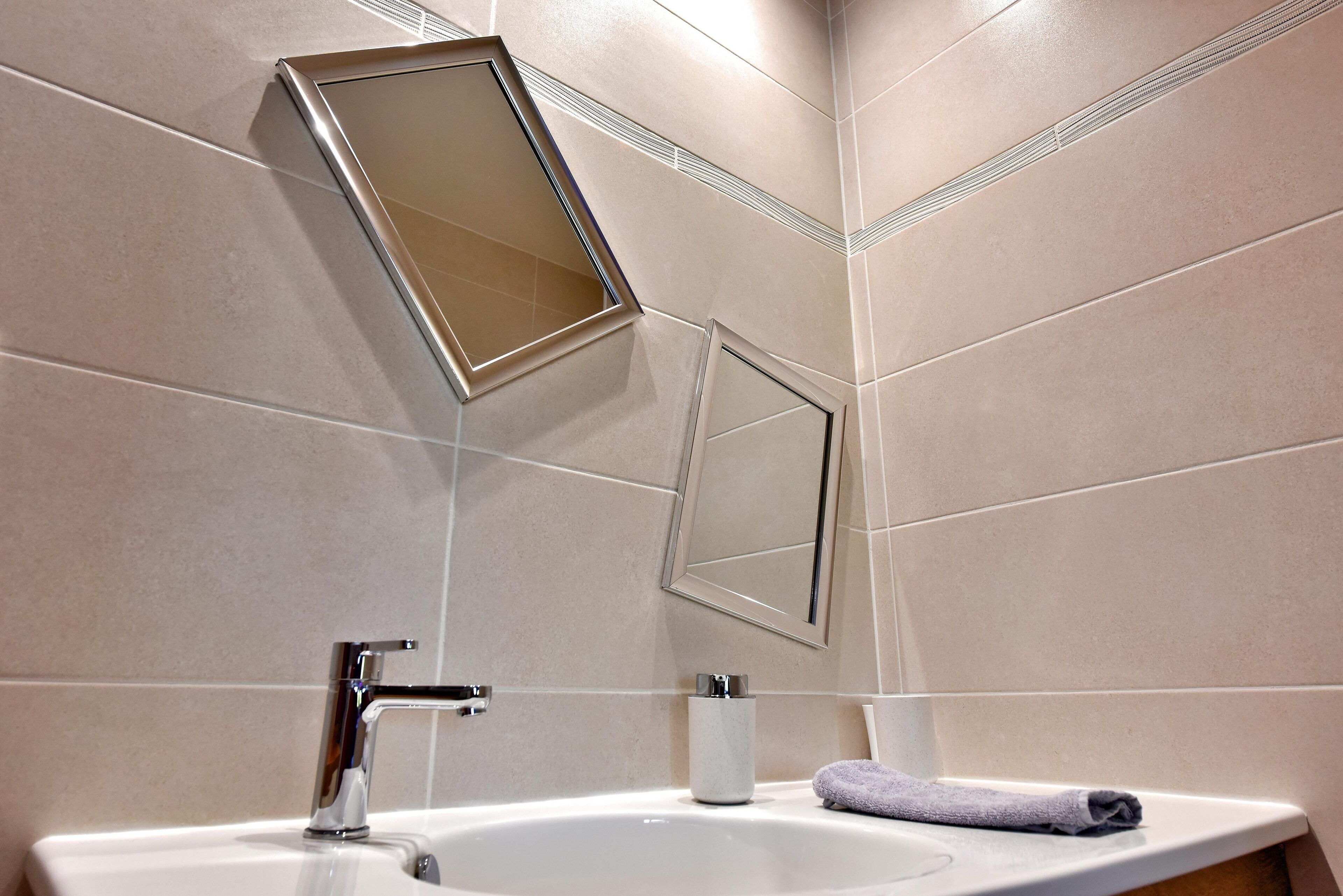 A bathroom with a white sink, a mirror, and a towel.