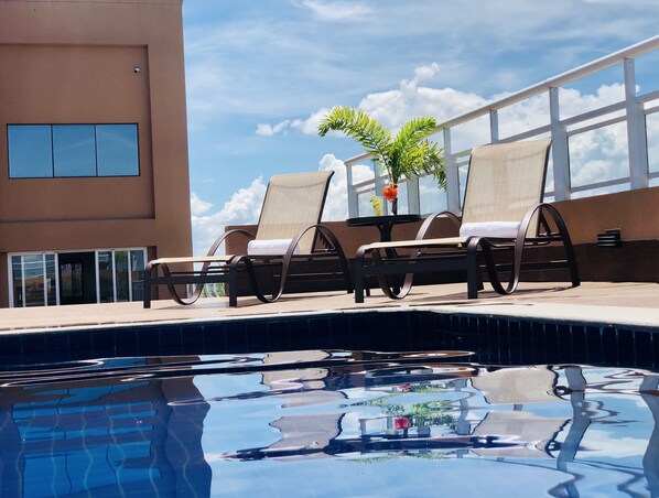 Alberca al aire libre, sombrillas en la alberca y camastros 