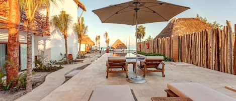 Una piscina al aire libre, sombrillas, sillones reclinables de piscina