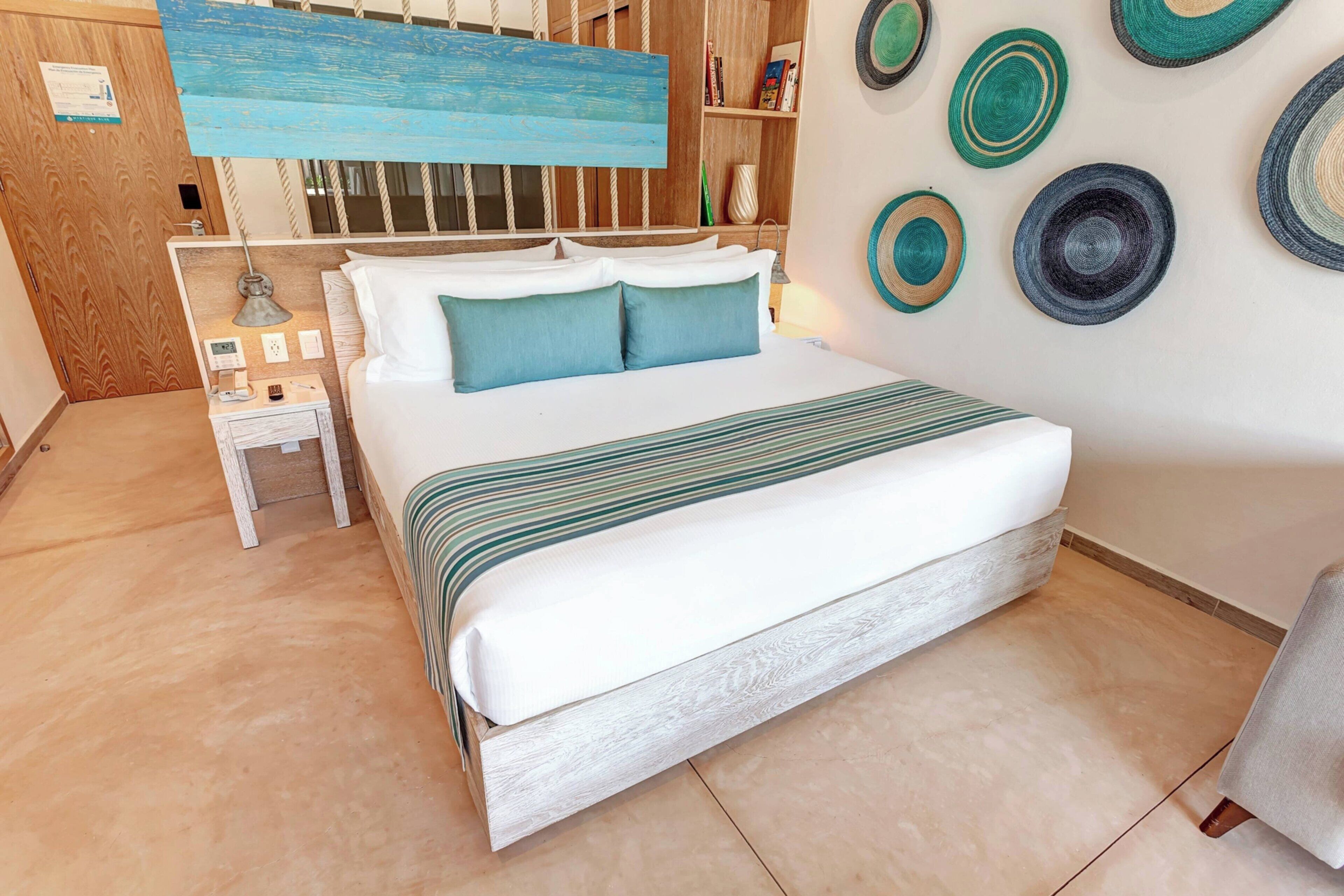 A neatly arranged bedroom with a bed, bedside table, and a wall decorated with circular patterns.