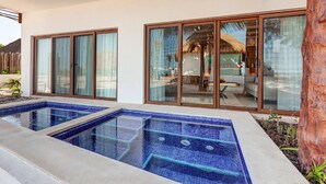A modern house with a swimming pool, large sliding glass doors, and a thatched roof visible through the windows. - Mystique Holbox by Royalton, A Tribute Portfolio Resort (Isla Holbox)