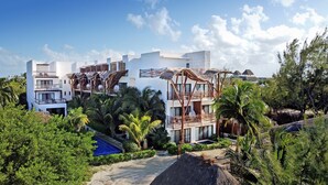 A modern hotel with multiple balconies, a pool area, and lush greenery. - Mystique Holbox by Royalton, A Tribute Portfolio Resort (Isla Holbox)