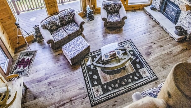 A spacious loft-style room with large windows, a fireplace, and a cozy seating area.