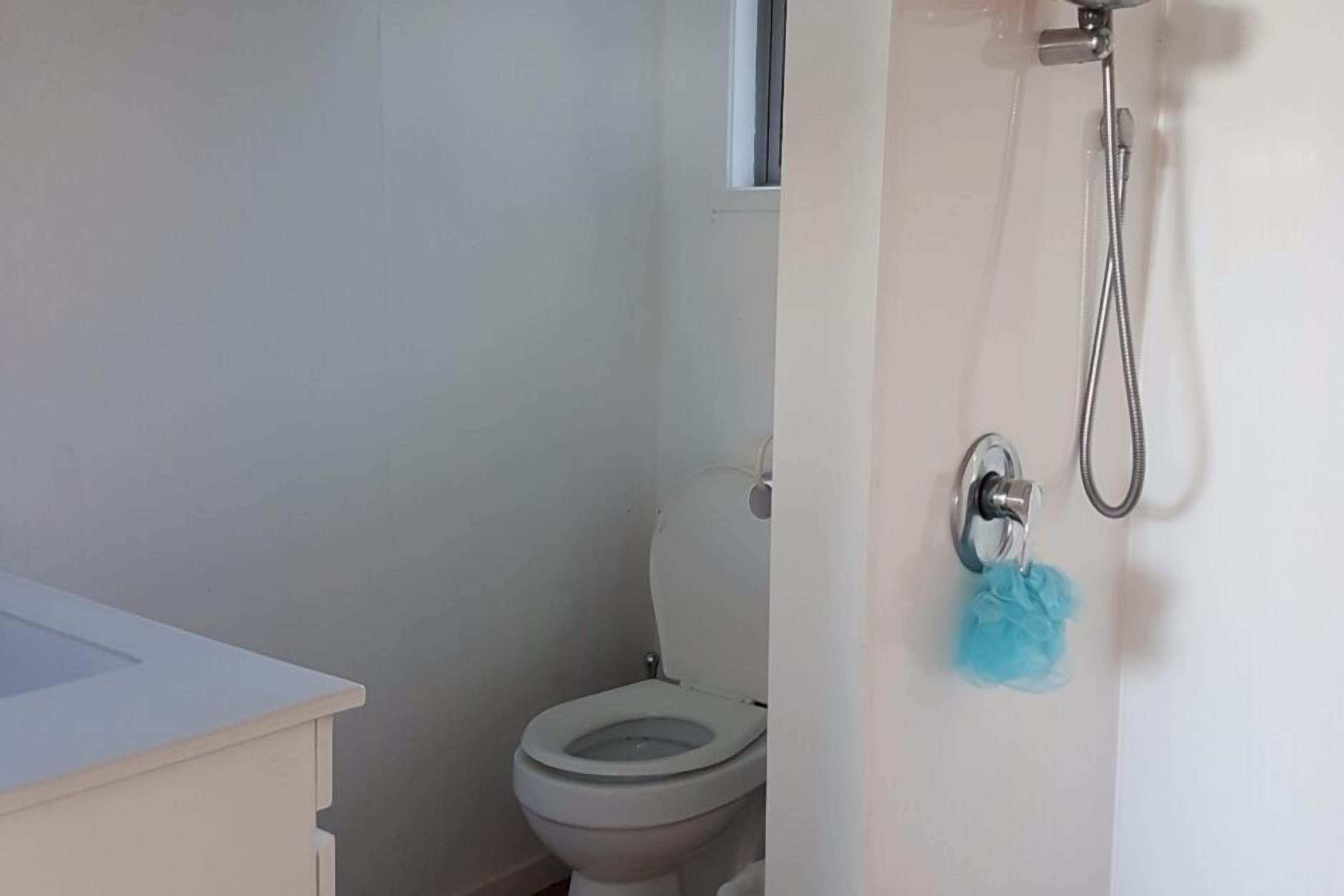 A bathroom with a toilet, a shower, and a sink.