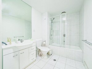 A modern bathroom with a white sink, toilet, and shower area. - Premier Stays Melbourne (Southbank)