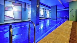 A modern indoor swimming pool with blue-tiled walls and a long, straight pool. - Premier Stays Melbourne (Southbank)