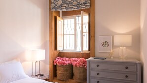 A bedroom with a bed, bedside table, lamp, dresser, and a window with a view. - ★Romantic - Casa Bela ★ Apartment with private terrace and shared garden (Porto)