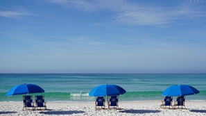 A beach with three blue umbrellas and beach chairs. - BEACHFRONT BEAUTY WITH AMAZING GULF VIEWS! (Fort Walton Beach)