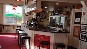 A bar area with a counter, stools, and a sign that reads "Wormald Brothers Spring Store". - Hampden Hotel (Murchison)