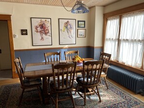 Enjoy meals in this elegant dining room with a wooden table and six comfortable chairs, surrounded by framed artwork and a beautiful rug.