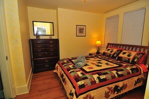 Un dormitorio con cama, cómoda, espejo y decoración en la pared.
